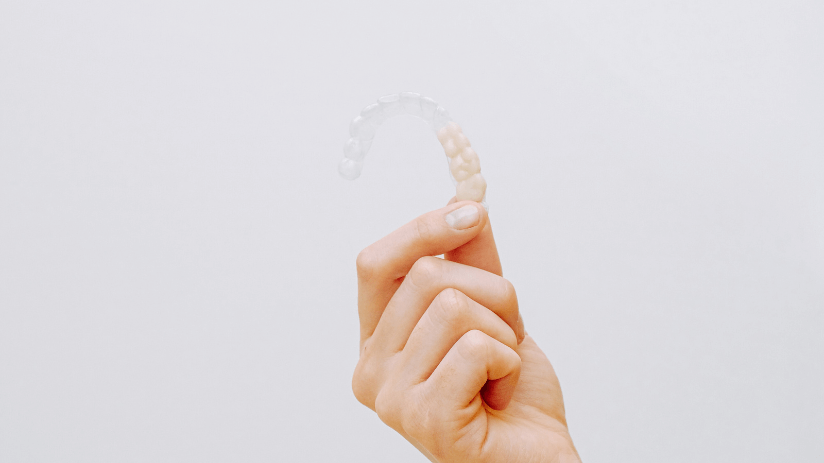 close up of hands holding Invisalign braces in Midhurst